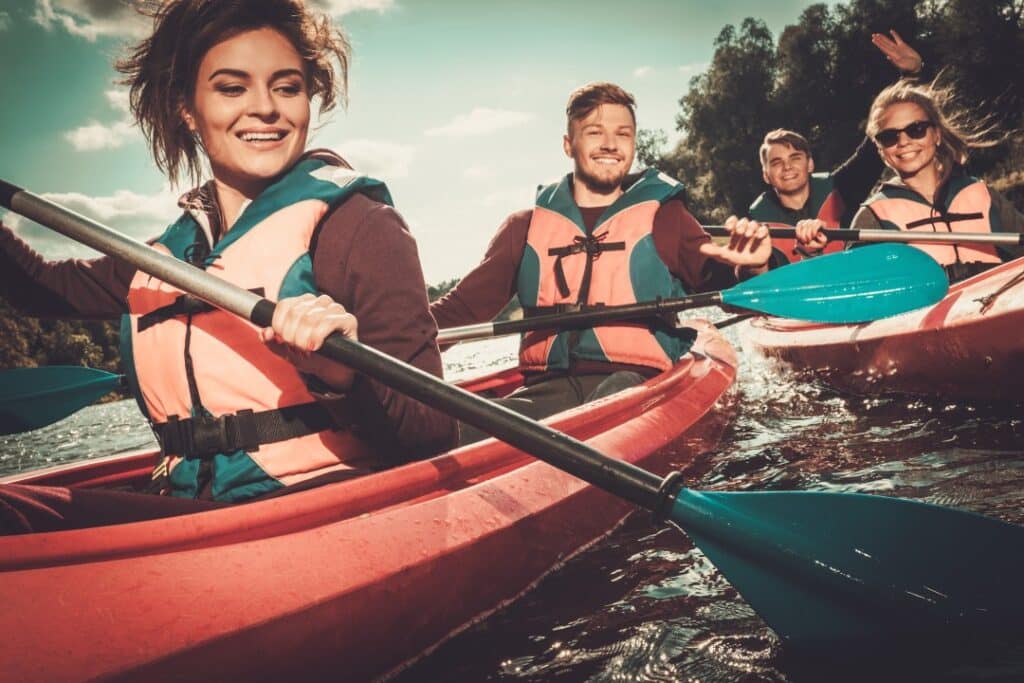 A close view of four people paddling in the sea