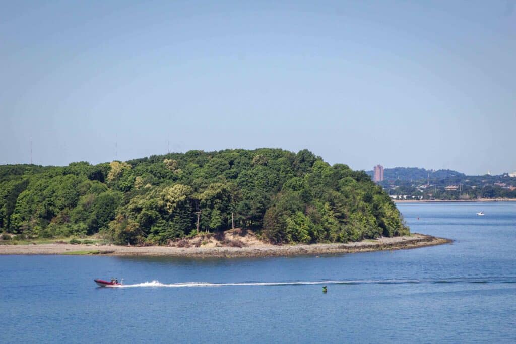 A faraway view of Boston harbor island with kayak moving around