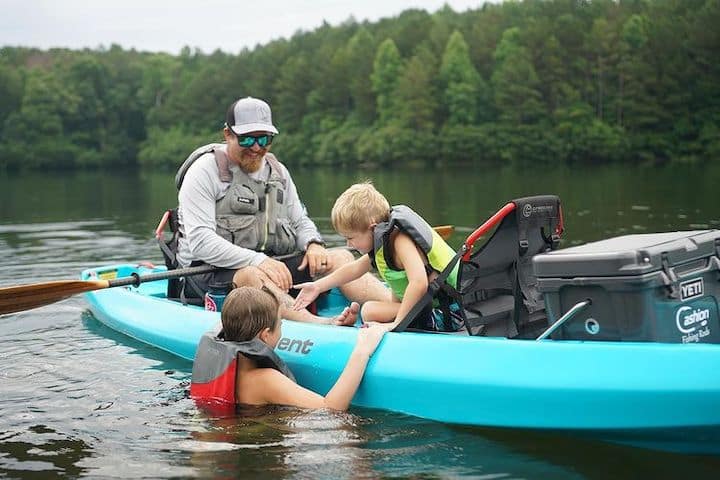 A guy enjoying kayaking with his two children