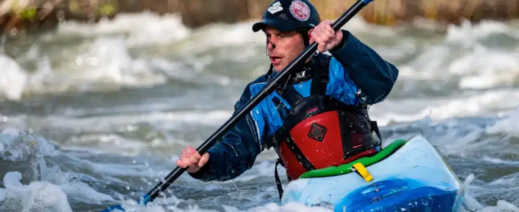 A person paddling through the sea waves wearing a life jacket