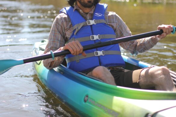 A view of a person wearing a life jacket paddling a kayak