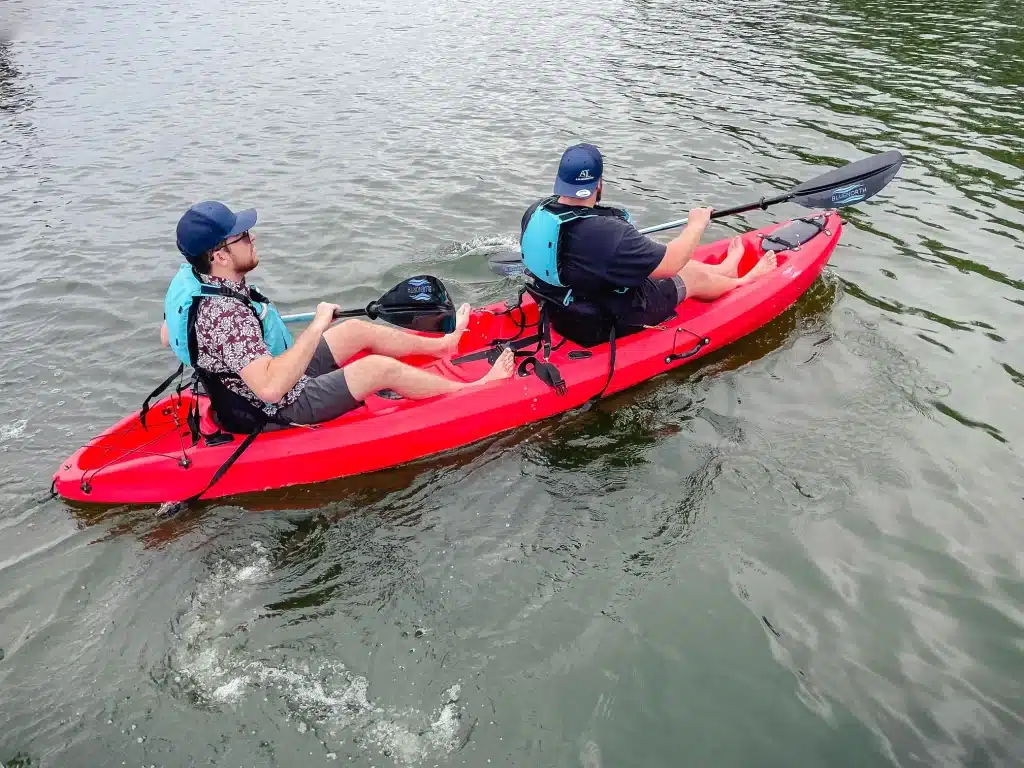 Two people sitting in a sit on top tandem kayak