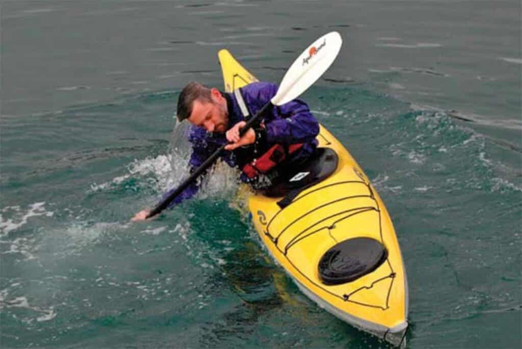 a person excuting back deck kayak roll