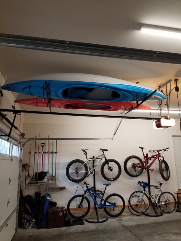 kayaks stored in garage along with bicycles and other gardening tools