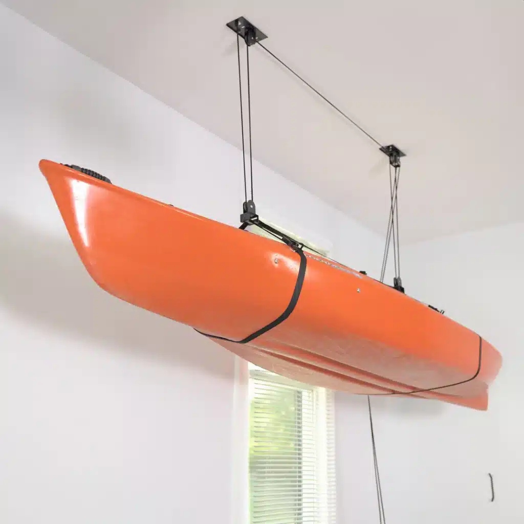 orange color kayak hanging with the help of ceiling hoists