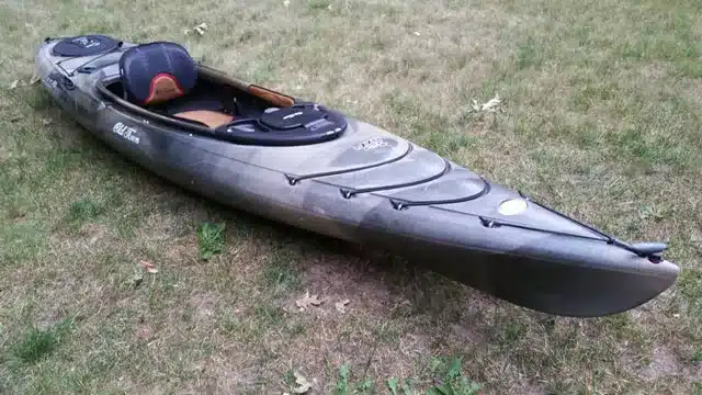 Old Town Loon kayak lying on a grass surface