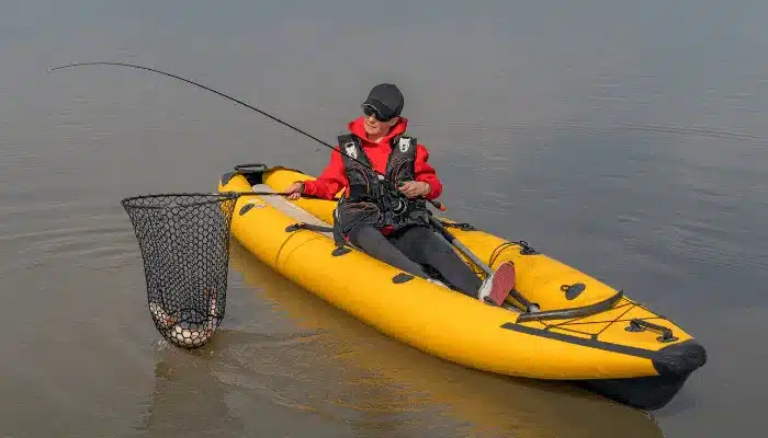 a lady sitting on a canoe with a fishing net in hand