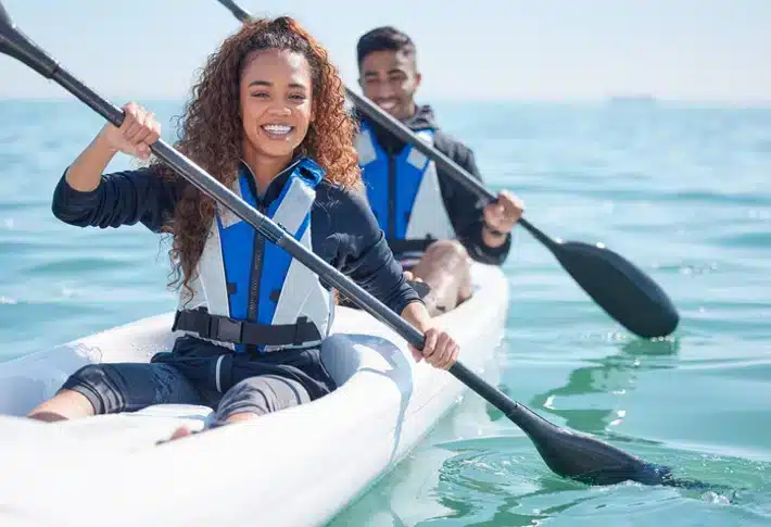 a man and a woman kayaking in water