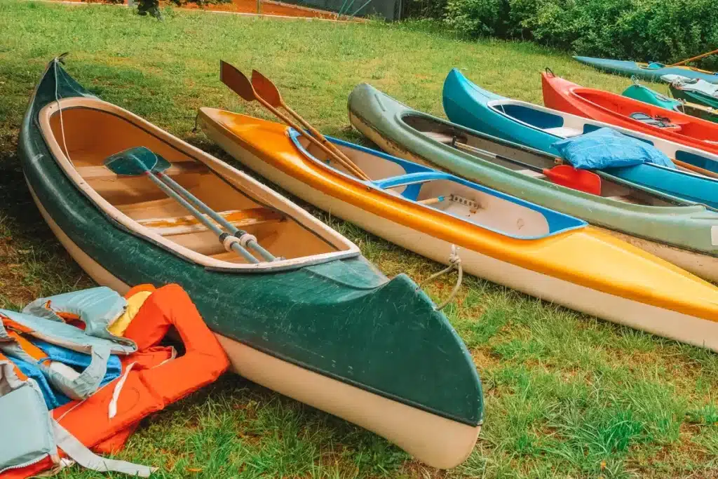 canoes and kayaks lying on a grass