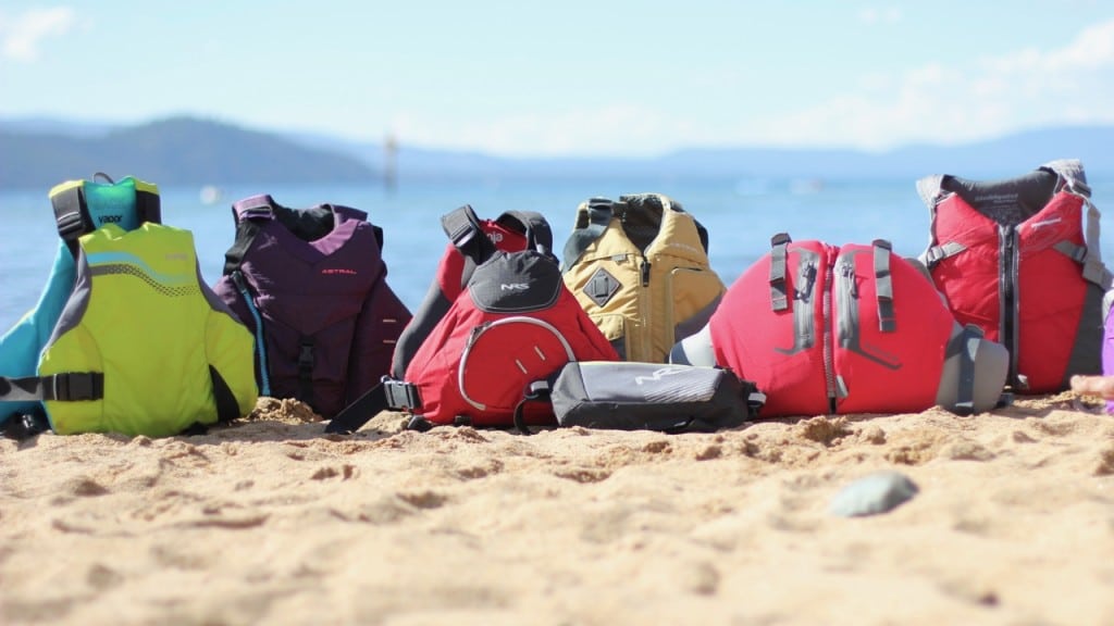 different types of life jackets placed on a beach