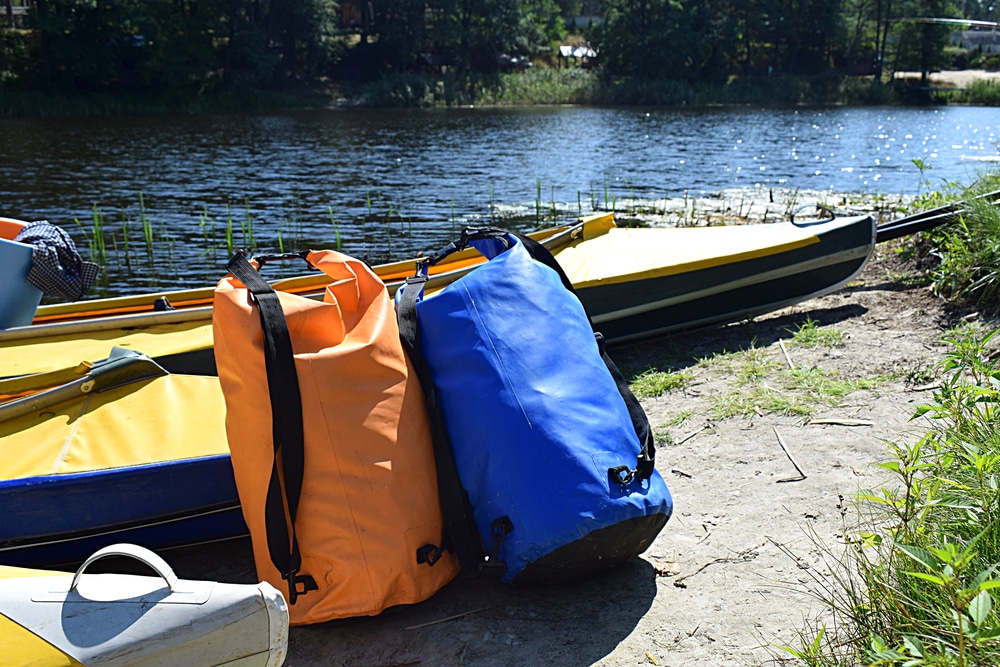 Kayaks And Airtight Gear Bags On The Beach While Parking