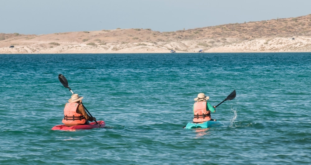 People Kayaking In The Baja At Tecolote Beach With Mountains