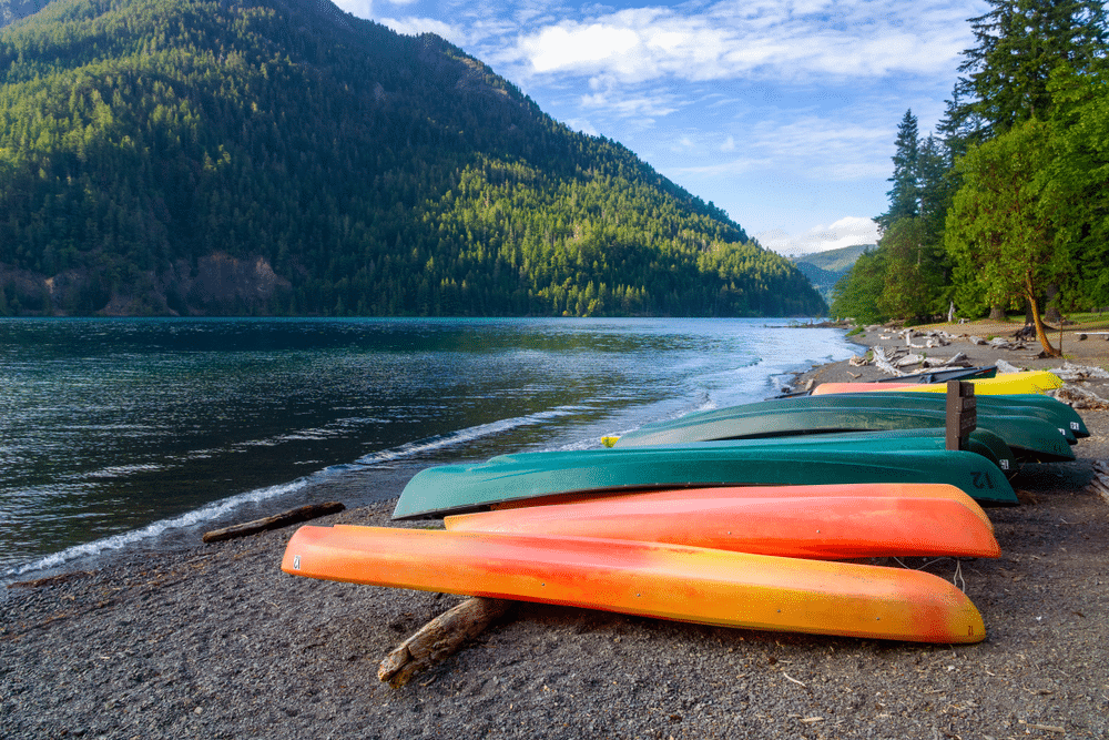 Row of colorful kayaks lying on the shore of Lake