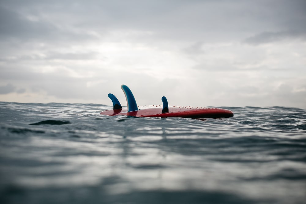 Retro Surfboard With Blue Fins Floating In The Ocean