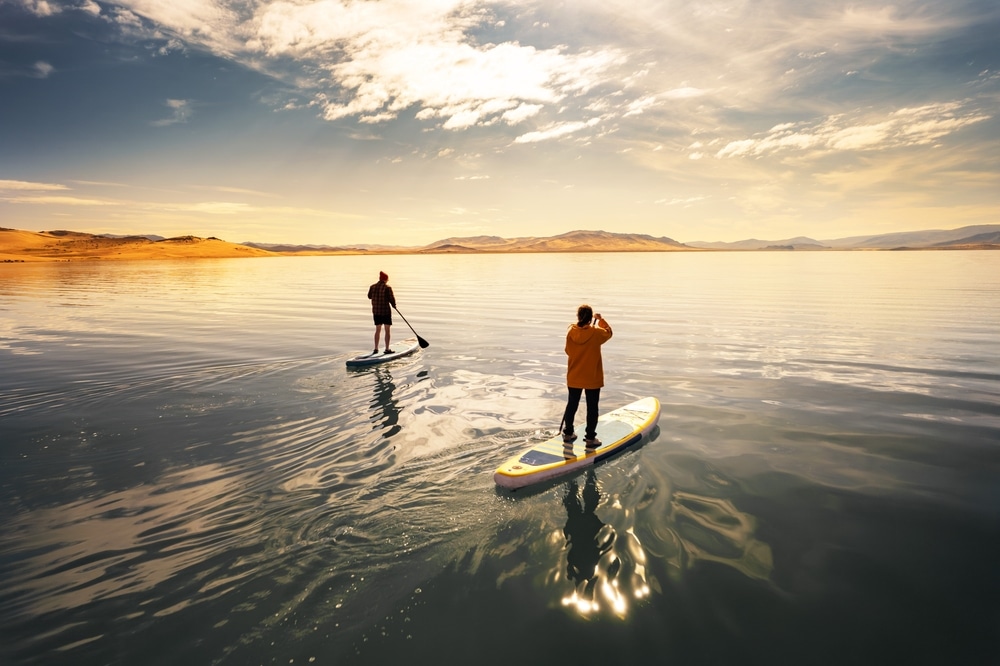 Two Active Young Tourists Are Walks On Stand Up Paddle