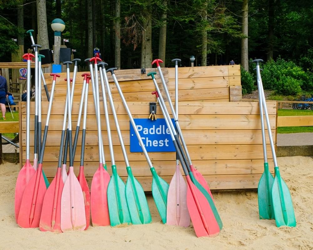 Colorful Paddles (oars) Resting Against Wooden Storage Box At A